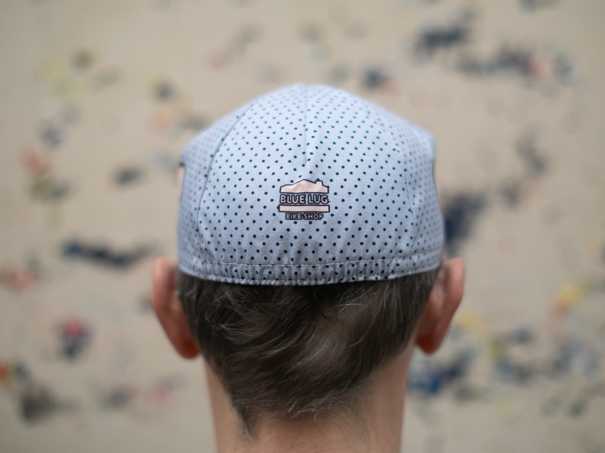 Rear view of the Blue Lug Good Boy Cycle Cap, showing the light blue polka dot crown and the small "Blue Lug Bike Shop" logo patch at the back.