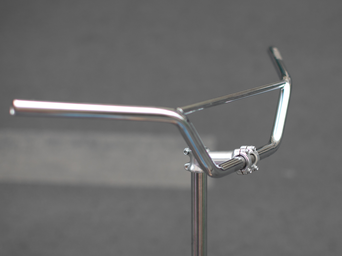 Magic Components Noppo Bar, three-quarter rear view showing the 30° backsweep and 10° upsweep. The crossbar brace and stem clamp area are visible in the foreground.